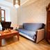 Hotel City Pisek in Písek: bright guest room with sofa, armchair, wooden coffee table and shelving