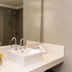 Duomi Hotel Buenos Aires bathroom vanity with sink, mirror, shower, and small flower vase in Buenos Aires