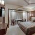 Hotel Centra-Ahmedabad in Ahmedabad guest room with double bed, table, chairs and wall-mounted TV