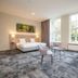 Fletcher Hotel Landgoed Huis te Eerbeek room with large windows, sofa and twin beds in Eerbeek