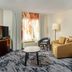 Fairfield Inn & Suites by Marriott Paducah guest room with sofa, desk, TV and patterned carpet
