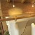 Appartement Sonnengarten in Ramsau am Dachstein: rustic loft bathroom with curved tub under wood ceiling