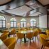 Leonardo Hotel & Residenz München dining room with arched windows and mustard chairs