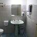 Alvares Cabral Guest House bathroom in Porto with toilet, sink, mirror, shower, and tiled walls