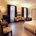 City Residence Apartment Hotel Košice room with bed, seating area, wardrobe, and TV