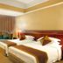 Rosedale Hotel Shenyang guest room with two twin beds, sofa, desk and warm lighting in Shenyang