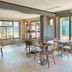 Campanile Nature - Sannois Ermont dining area with tables, chairs, and large windows overlooking greenery