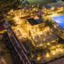 Apollo Resort Art Hotel in Kyparissía, aerial view of lit resort with glowing outdoor pool and terraces