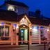 Ashbys Accommodation & Spa hire, Portsmouth: lit exterior entrance with flower boxes at dusk