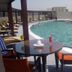 Raf Hotel Apartment in Dubai rooftop pool with lounge chairs and table beside the water