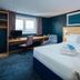 Travelodge Newbury Tot Hill guest room with bed, desk, and window view