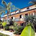 Residence Esmeraldo in Capo Vaticano with tropical garden and balconies under a bright blue sky