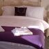 Grove House Hotel, Woodbridge: bedroom with a white bed, purple throw, folded towels, and bedside tables