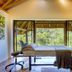 The Cavern in Bonjaneni treatment room with massage bed and large forest-view windows