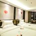 Dunhe Apartment Guangzhou twin beds with city-view window and curtains in a modern hotel room