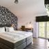 Hotel Ulmenhof & Spa in Bredstedt: modern guest room with double bed, desk and balcony doors