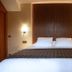 Hotel Le Clos De La Vouge, Vougeot: double bed with tall wood headboard and wall lamps in a guest room