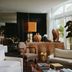 Palm Heights in North Side lounge with wicker console, coffee table books, and tall windows