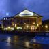Hotel Valle de Cabezón in Cabezón de la Sal at night with illuminated facade and wet parking area