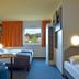 B&B Hotel Augsburg-Süd room in Augsburg with twin beds, desk, orange curtains and window view