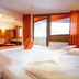 Hotel Garni Romantika in St. Leonhard im Pitztal guest room with bed, seating area, and mountain-view windows