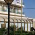 Santa Beach Hotel in Agía Triáda with balconies, glass-fronted facade, and palm-lined entrance
