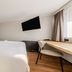 Campanile Nature - Sannois Ermont guest room with double bed, desk, wall TV and green accent wall in Sannois