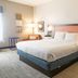 Hampton Inn Atlanta/Peachtree City guest room with king bed, bedside lamps, and neutral carpet in Peachtree City