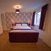 G Boutique Hotel Portsmouth guest room with double bed, patterned accent wall, wooden floor, and window