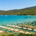 Ozkaymak Marina Hotel in Kemer with beachfront umbrellas, turquoise bay, and forested hills