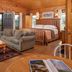 Engadine Inn and Cabins in Candler: rustic cabin suite with king bed, sofa, coffee table and mountain views