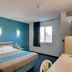 Econo Lodge Menomonie room with bed, desk, wall lights and window in Menomonie
