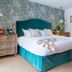 Cotswold Plough Hotel & Restaurant in Bampton guest room with teal upholstered bed and floral throw