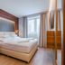 Charm Hotel Budapest, Budapest: modern guest room with double bed, wood paneling and window curtains