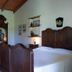 Domo Minnannu Miriu room in Loiri Porto San Paolo with carved wood bed and armoire