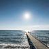 Kurhotel Skodsborg in Copenhagen with a long pier extending into the ocean under a bright sun.