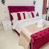 G Boutique Hotel in Portsmouth guest room with magenta tufted bed, armchair and large window