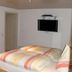 Jaegerstube in Görgeshausen guest room with bed, wall-mounted TV and mirror
