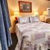 Governor's Rock Motel in Shaftsbury guest room with bed, armchair, lamps, and sliding glass door