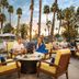 Guests relax by the pool at Omni Rancho Las Palmas Resort & Spa in Rancho Mirage with palm trees at sunset.