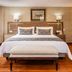 Hotel Porton De La Cabrera in Bogotá guest room with king bed, bench, window and wood floors