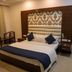 Hotel Park Plaza Chandigarh room with a king bed, patterned headboard, and seating by the window