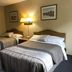 Coastal Inn - Kingfisher in Digby: hotel room with two double beds and bedside lamp