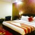Hotel Daya Continental New Delhi guest room with double bed, armchairs, and patterned accent wall