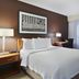 Residence Inn by Marriott Greenville-Spartanburg Airport guest room with king bed, desk, TV and window drapes in Greenville
