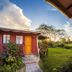 Keuhenua Hostal in Hanga Roa with colorful cabins and a garden path at sunset
