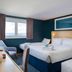 Travelodge Dartford room with three beds, window view and teal walls in Dartford