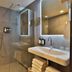 Hotel Abdij Dokkum bathroom with glass shower, vanity sink, mirror, and folded towels in Dokkum