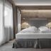 Hotel Ciasa Salares bedroom in Badia/Abtei with king bed, wood-paneled wall and soft lighting