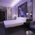 Orange Hotel Beijing Tianning Temple guest room with king bed, sofa seating and colorful deer mural in Beijing